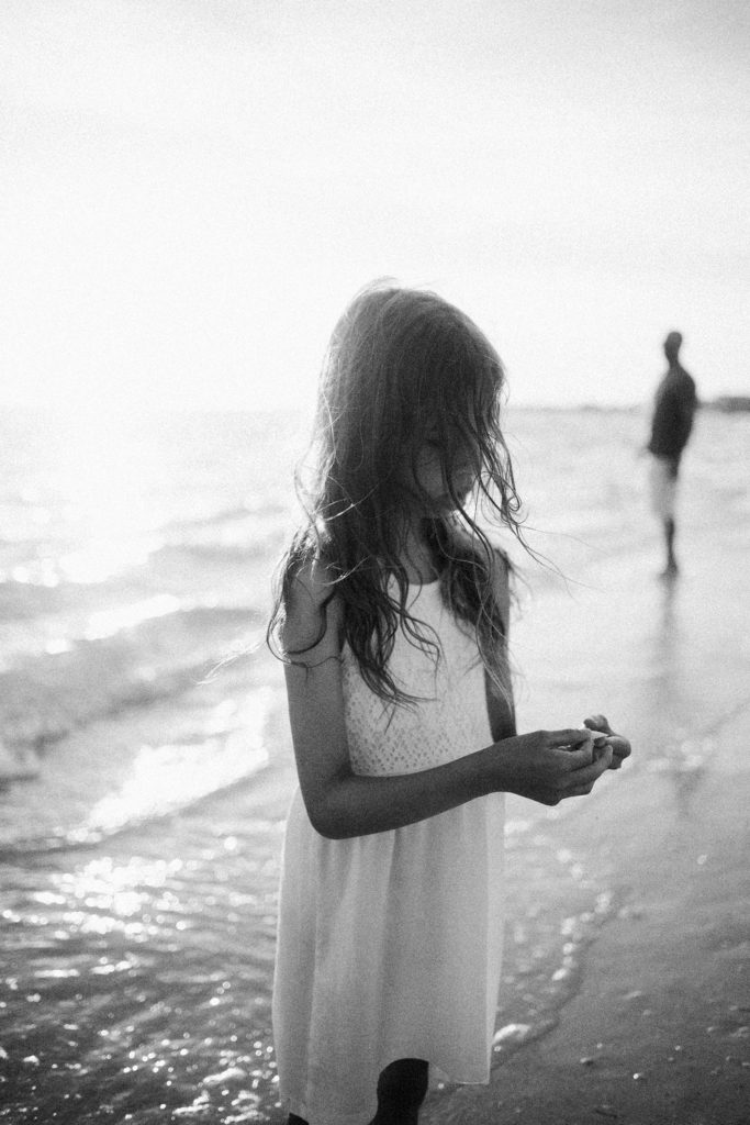 black and white image of girl at beach