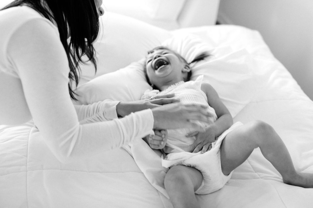 Studio lifestyle session tickle time between mom and daughter