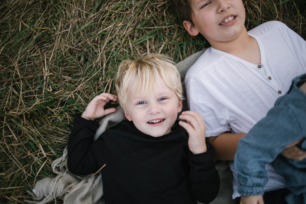 Elle Baker Photography photographs Large family sessions in Chicago. Photo of a young boy laughing with his siblings.