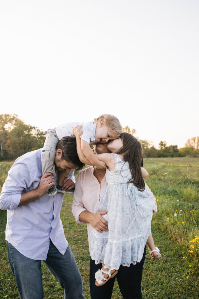 Frankfort Family Photographer family hug in field during lifestyle session 