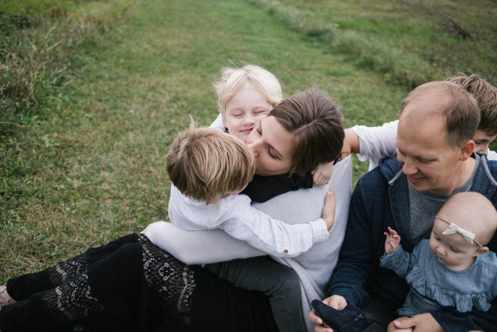 Large Family Sessions is Elle Baker photography's specialty. Four siblings and mom cuddling and laughing