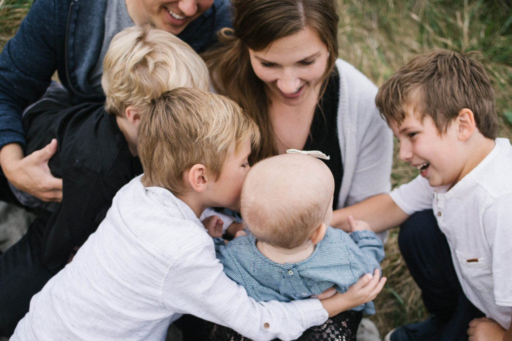 Family of six in a large family sessions by Elle Baker Photography. Laughing and kissing siblings
