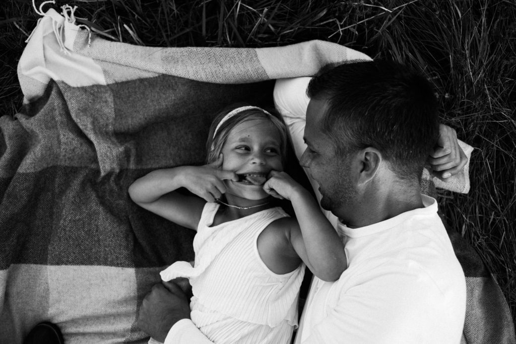 let's go fly a kite | Elle Baker Photography | father and daughter snuggling on blanket during session