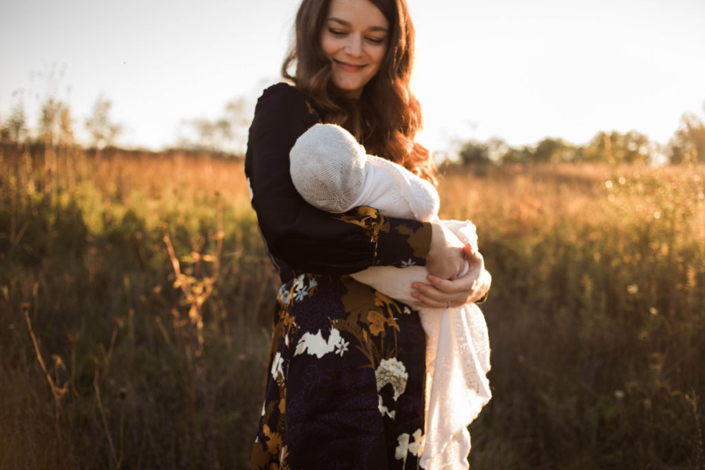 Naperville Illinois Forest Preserve, Photos by Elle Baker Photography, new mom and newborn baby girl wearing a white bonnet at sunset session, newborn posing ideas