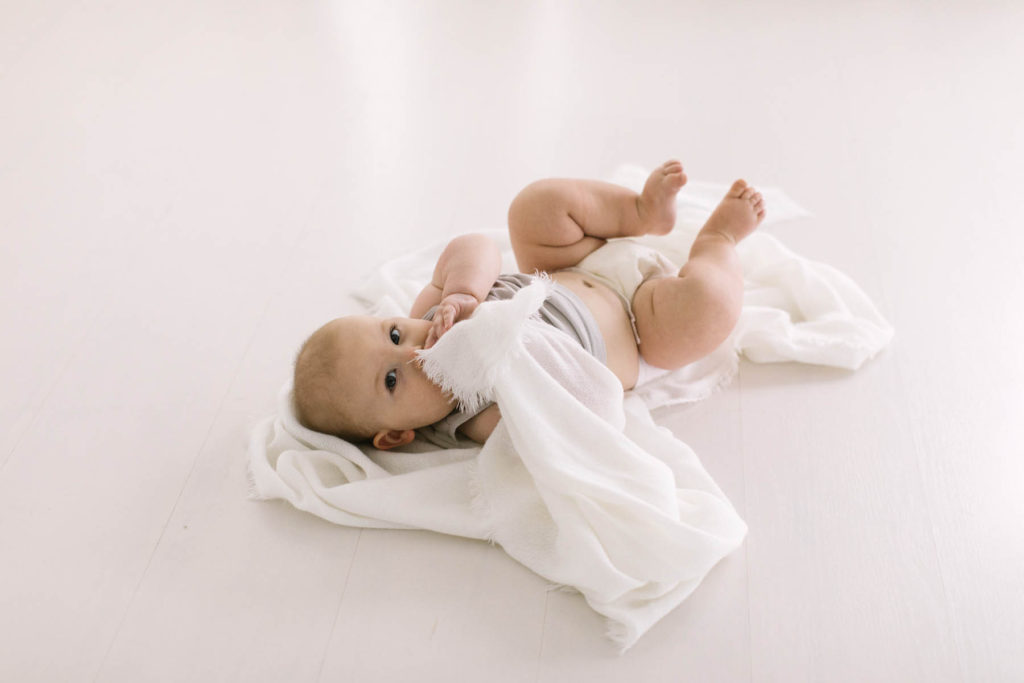 Tips For a Successful Baby Milestone Session, Chicago baby photographer, Photos by Elle Baker Photography, baby boy laying on his back eating a blanket, detail shot
