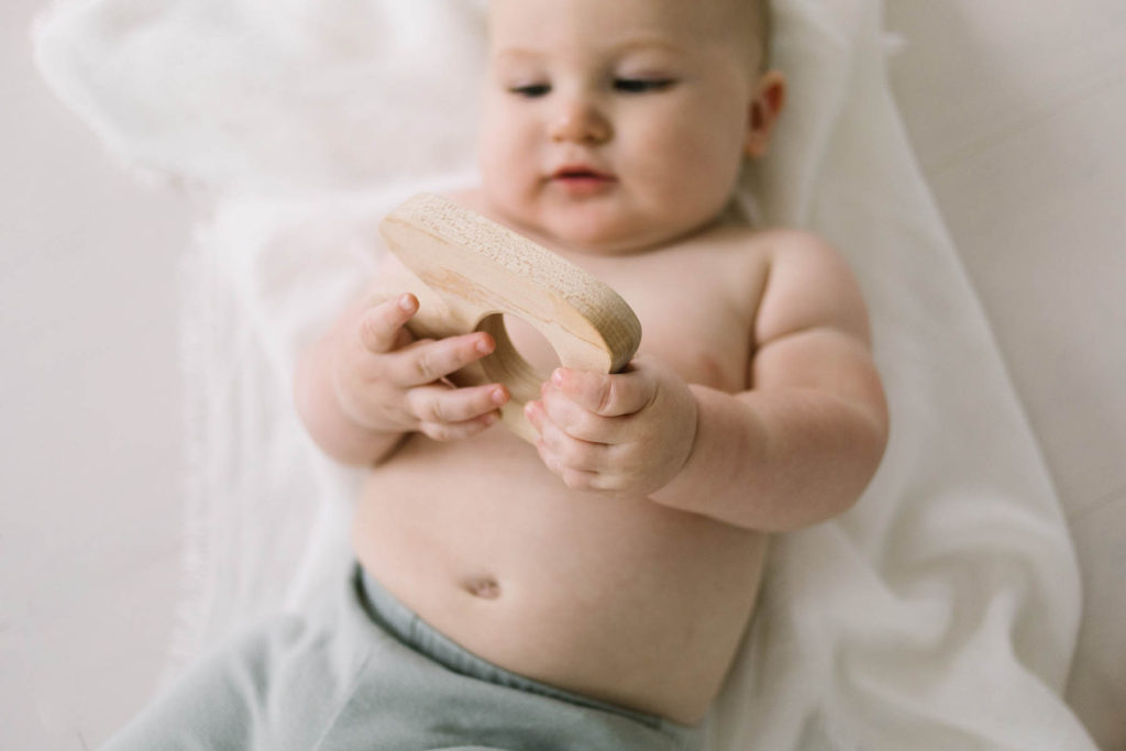 Detail shots during a baby session, Elle Baker Photography, La Grange Illinois baby photographer, baby boy holding wooden tooth toy in white studio
