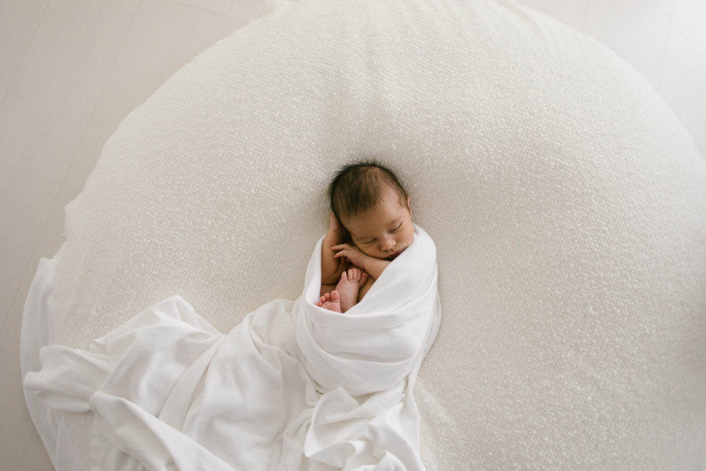 Homer Glen, IL newborn photography studio, Photo by Elle Baker Photography, newborn swaddled in white wrap in a white studio