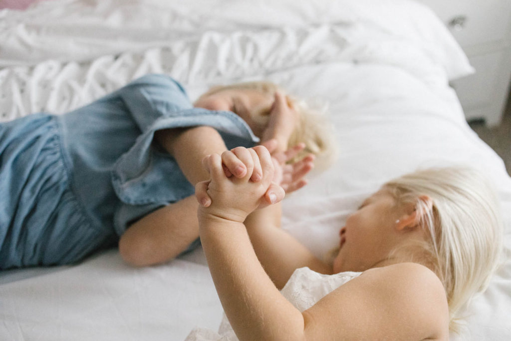 In home lifestyle session, Photos by Elle Baker Photography, Chicago photographer, two little girls playing on a bed 