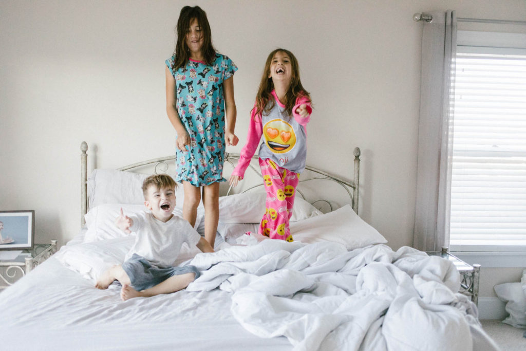 On Saturday's we wear pajamas in New Lenox, IL, Photos by Elle Baker Photography, three children jumping on a bed