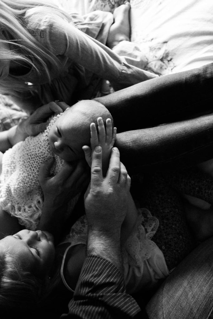 Chicago newborn and family lifestyle photographer, Elle Baker Photography, siblings gently placing hand on newborns head