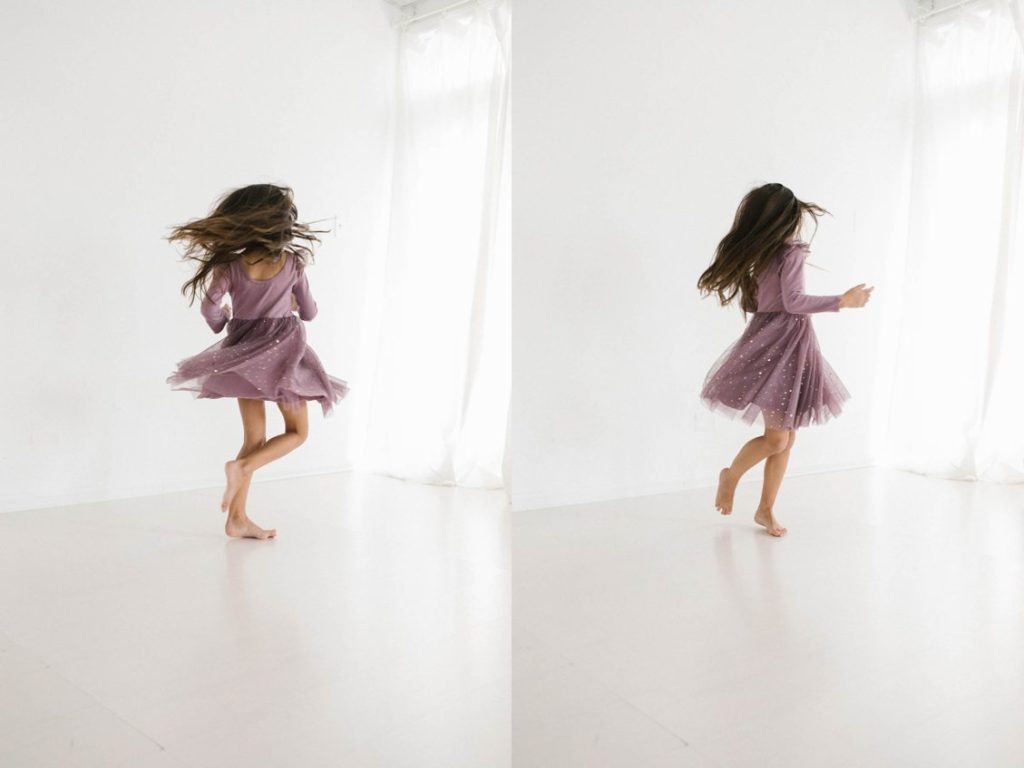 Family Photographer in Naperville, Illinois, Photo by Elle Baker Photography, young girl twirling in an Ele story dress, sparkly purple dress in white studio