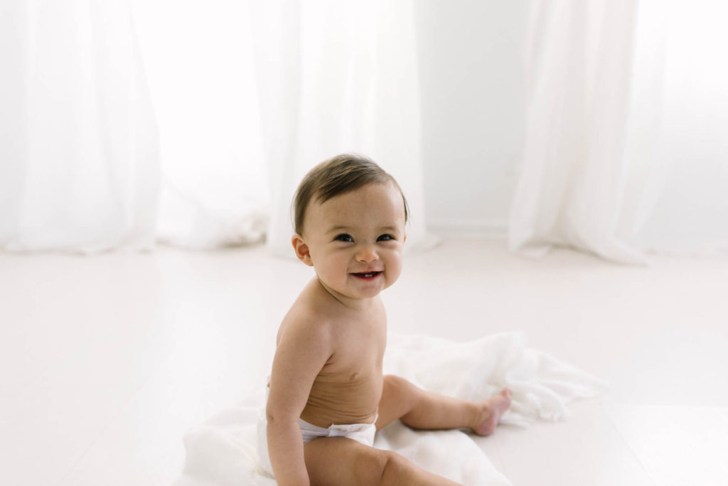 Simple and natural baby session, Photo by Elle Baker Photography, baby girl in white studio space in Chicago smiling
