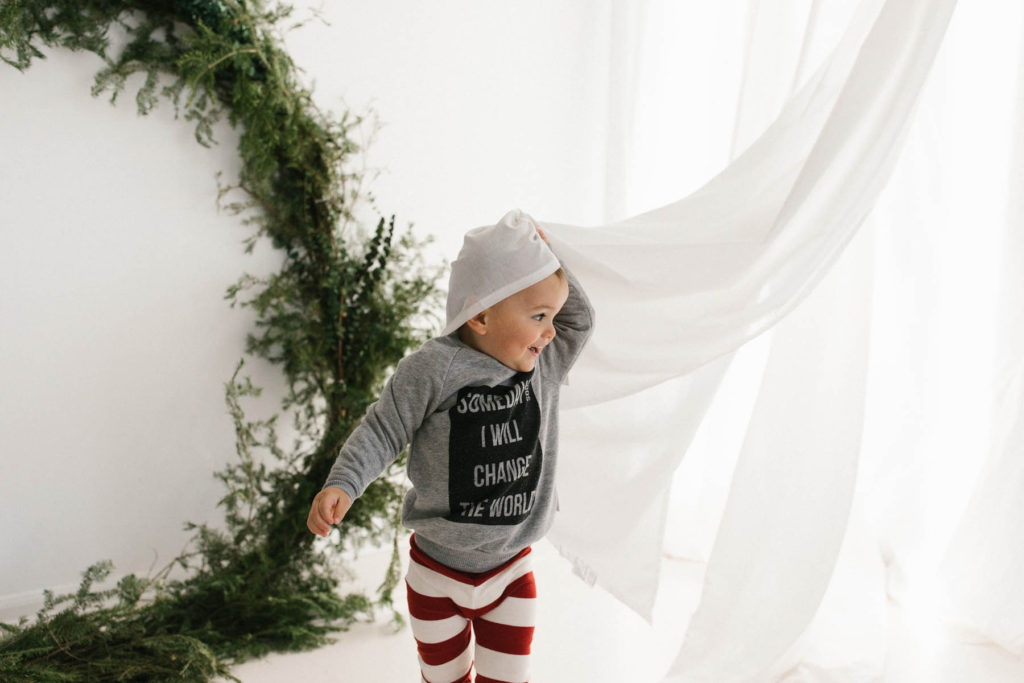 Homer Glen, IL Holiday Mini Sessions, Photo by Elle Baker Photography, boy playing in curtains in Chicago studio