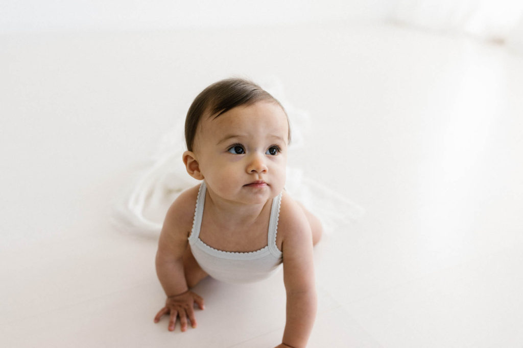 simple and natural baby session, Photo by Elle Baker Photography, baby girl in white studio space in Chicago smiling