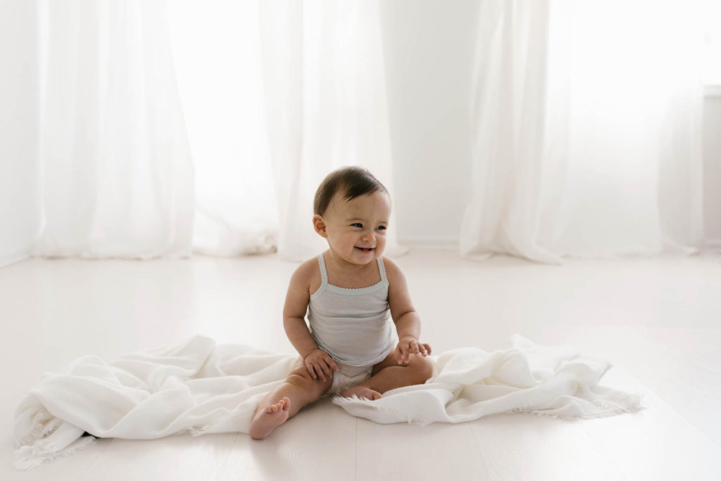 simple and natural baby session, Photo by Elle Baker Photography, baby girl in white studio space in Chicago smiling