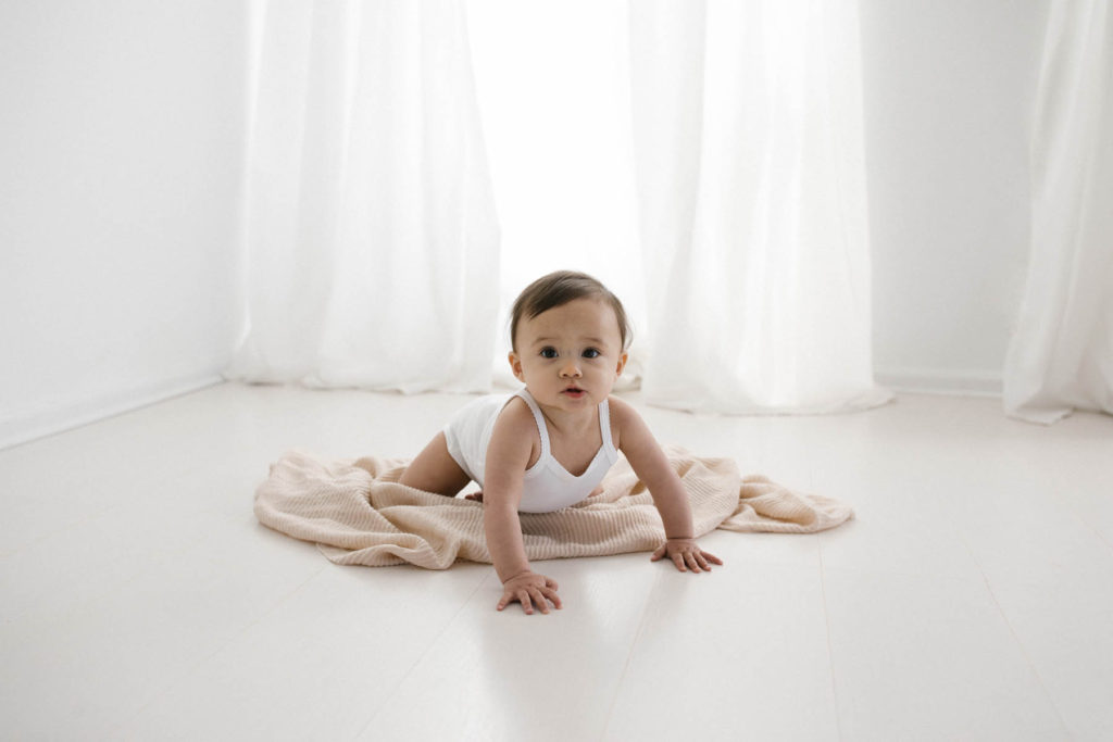 Simple and natural baby session, Photo by Elle Baker Photography, baby girl in white studio space in Chicago crawling around