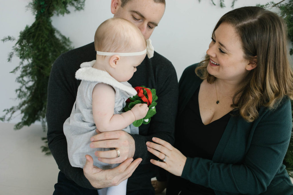 Christmas card photo ideas, Photo by Elle Baker Photography, family of three at holiday wreath session