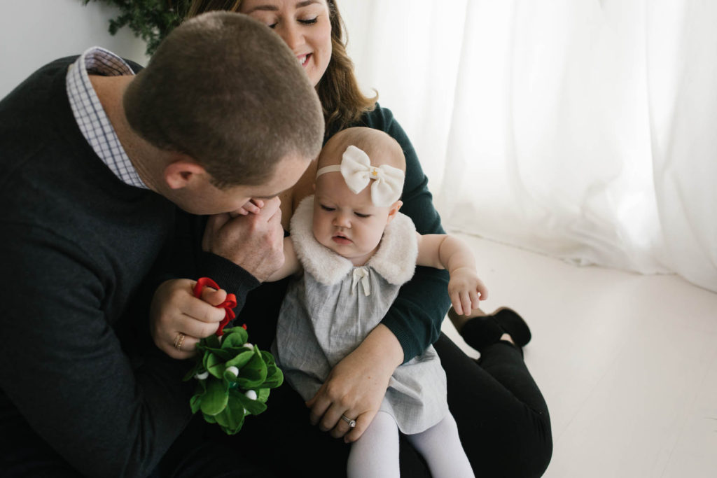Christmas card photo ideas, Photo by Elle Baker Photography, baby girl being kissed on the hand by her daddy