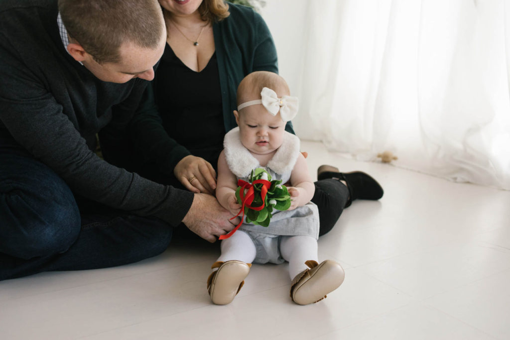 How to pose large families in small spaces, Frankfort IL family photographer, Elle Baker Photography, family of three with young baby playing with holiday decor