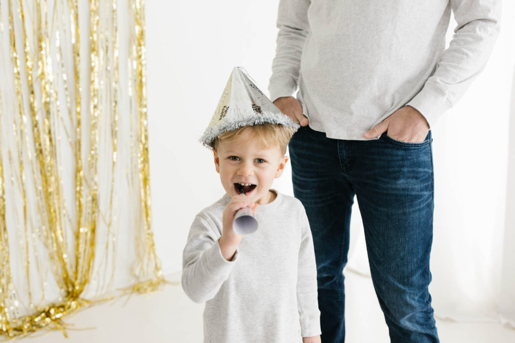 New Year's Photo Session, Photos by Elle Baker Photography, Little boy wears New year's hat and noise maker during studio session
