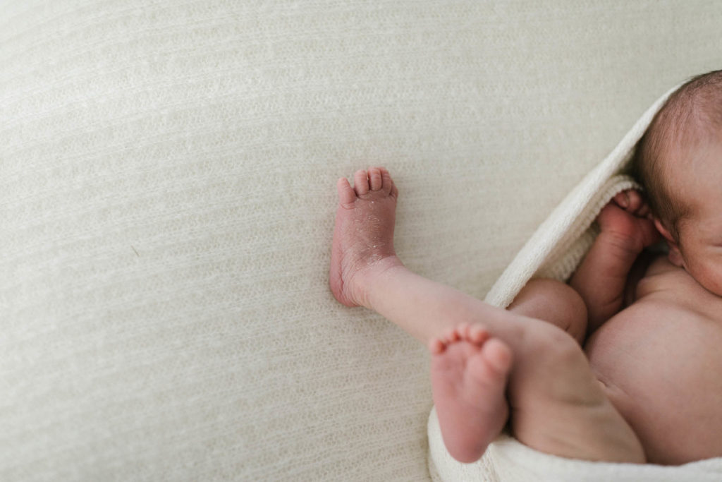Captured in Elle Baker Photography's Chicago newborn photography studio, this image is a detail photo of a newborn baby's foot and toes