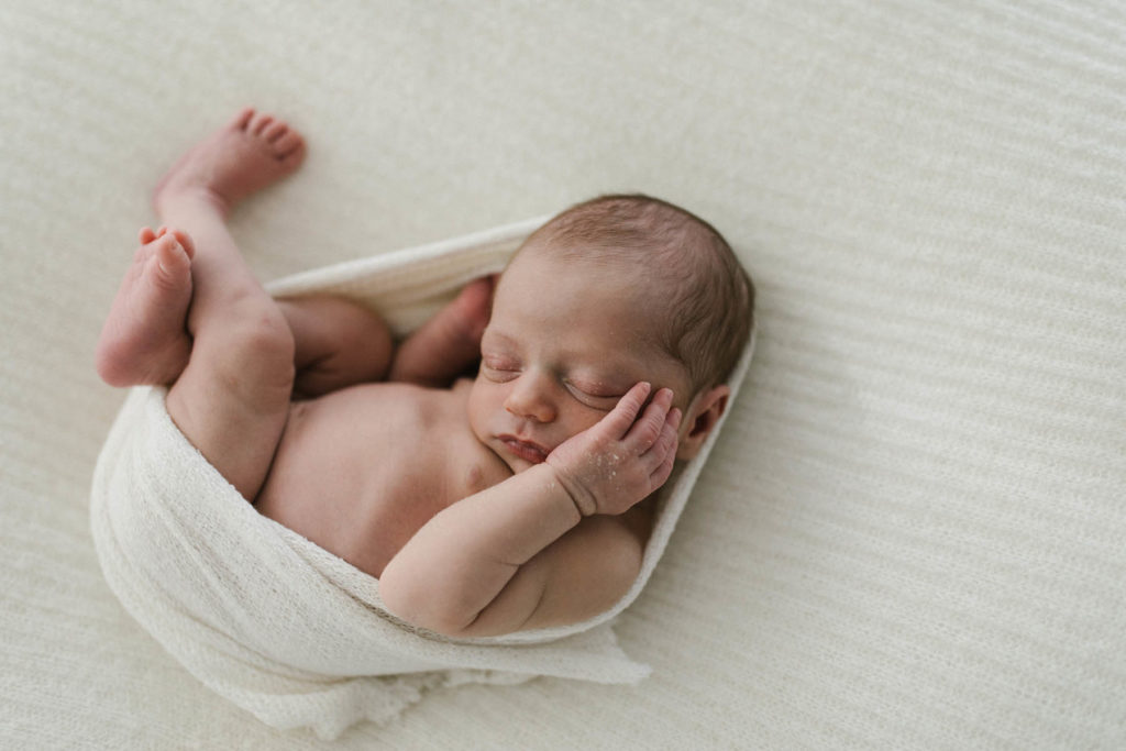 newborn baby laying on a neutral set up at a Chicago newborn photography studio