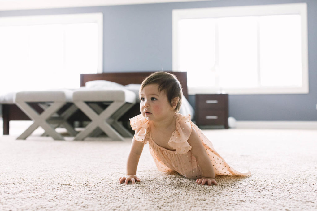baby girl crawling wearing a peach and gold dress 