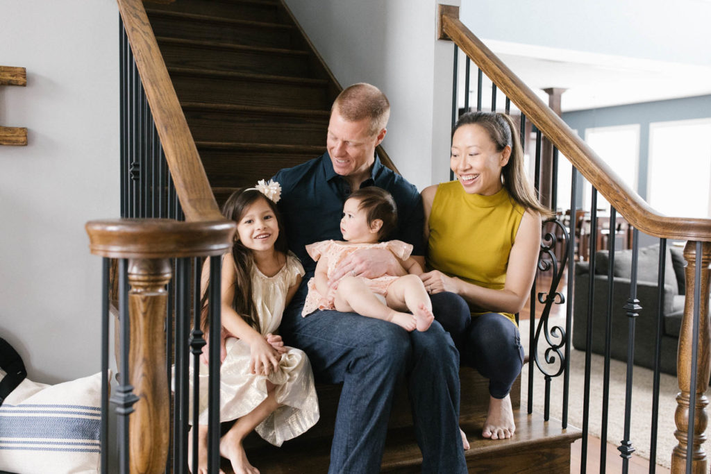 family of four sitting on stairs smiling 