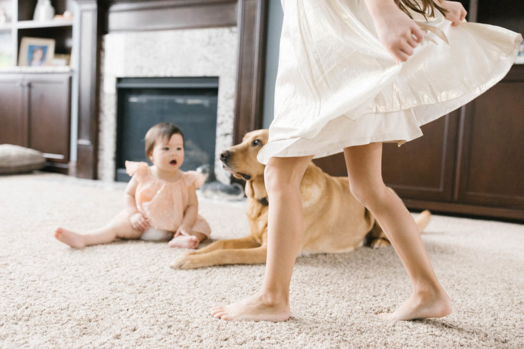 girl in a gold dress twirls in the family room during family session 