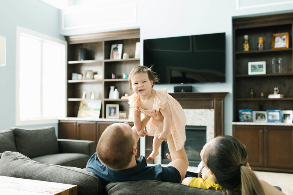 dad plays airplane with his baby during lifestyle session with Elle Baker Photography 