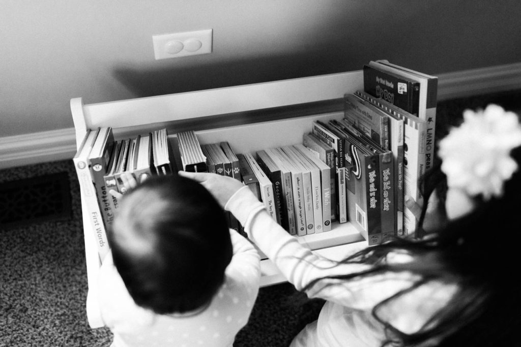 in home session with two little girls looking through books