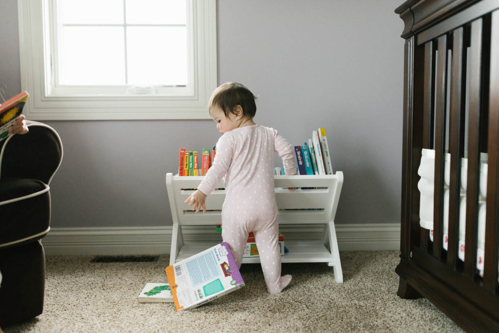 baby girl throwing her books down 