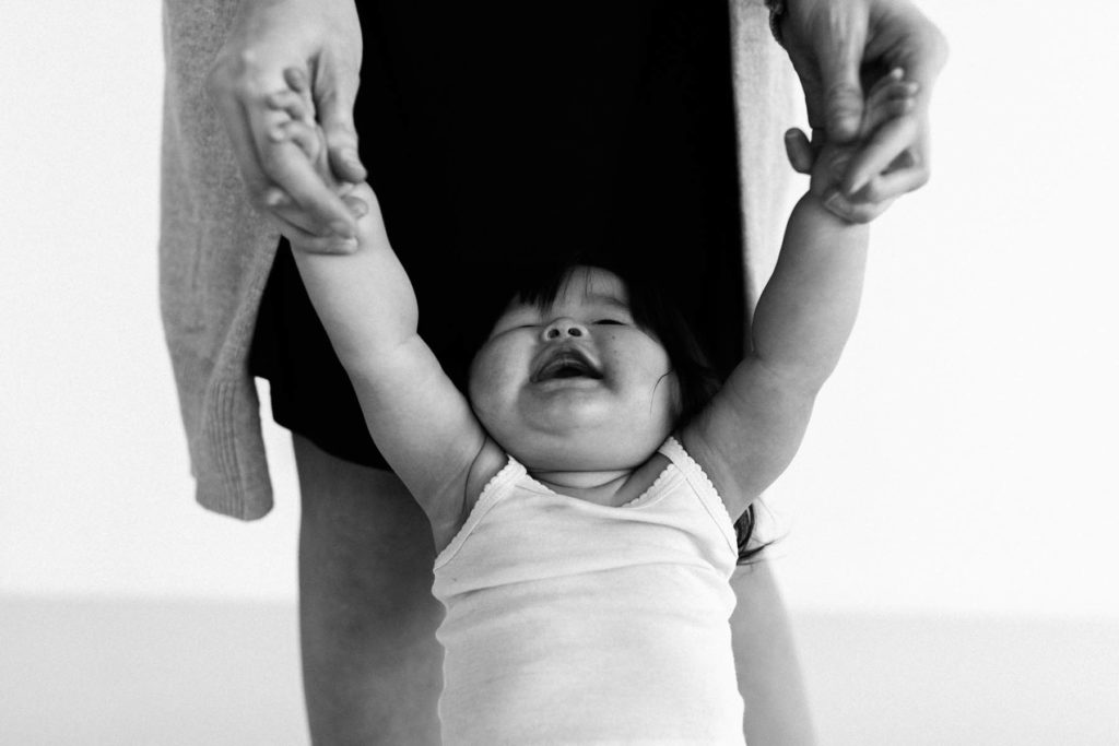 black and white image of a baby girl looking up at her mom