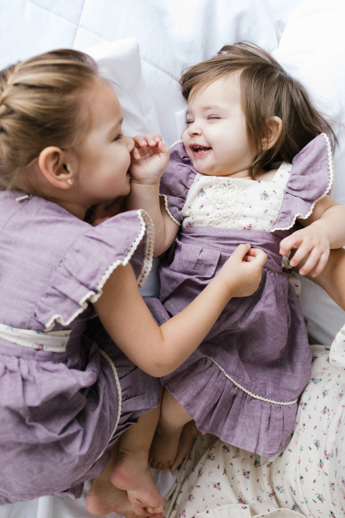 two little girls laughing during a family session with Elle Baker Photography 