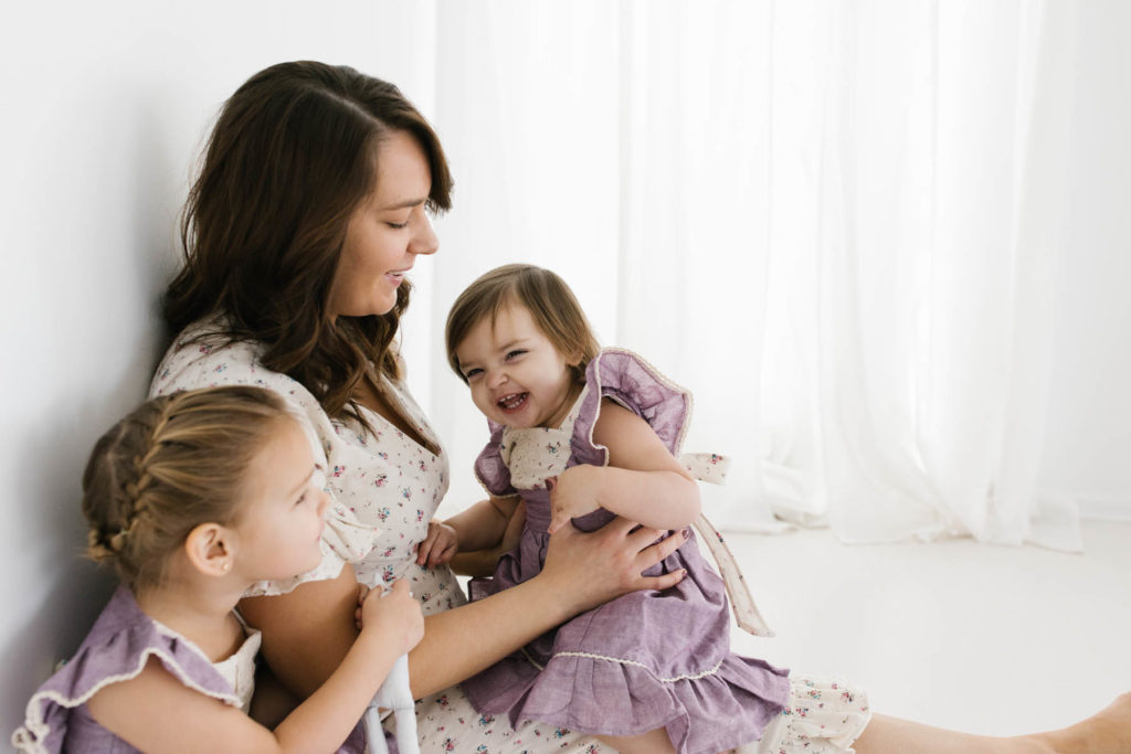 mom and two daughters laugh during photo session with Elle Baker Photography