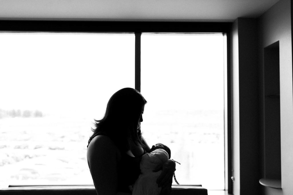 black and white image of woman holding baby boy 