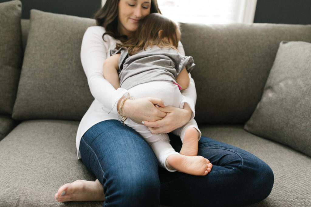Mother holding her toddler daughter during lifestyle session with Downers Grove photographer Laurie baker 