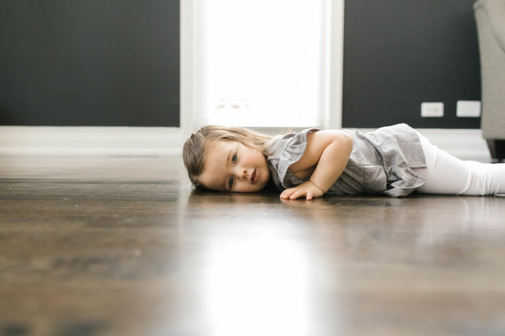 daughter lays her face down on the floor, captured by Elle Baker Photography, Downers Grove family photographer