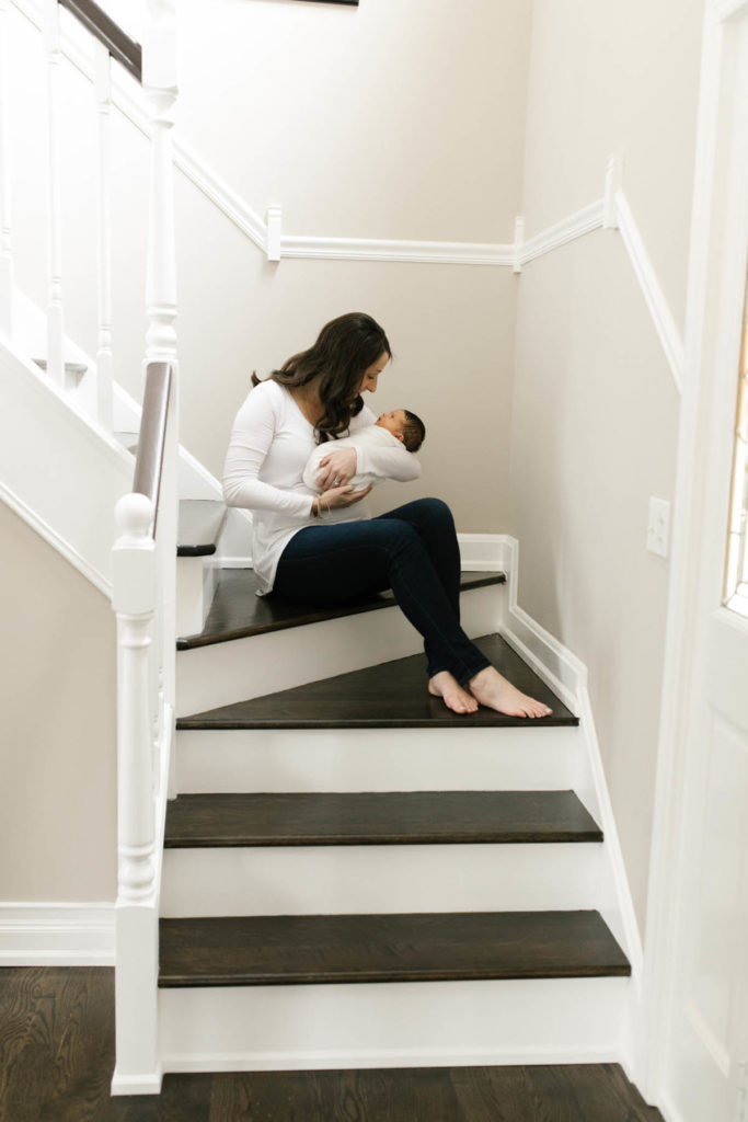 Downers Grove family photographer, Laurie Baker captures woman sitting on stairs with newborn girl 
