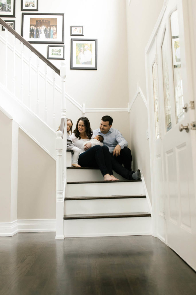Family photographer Laurie Baker captures family of four sitting in staircase.