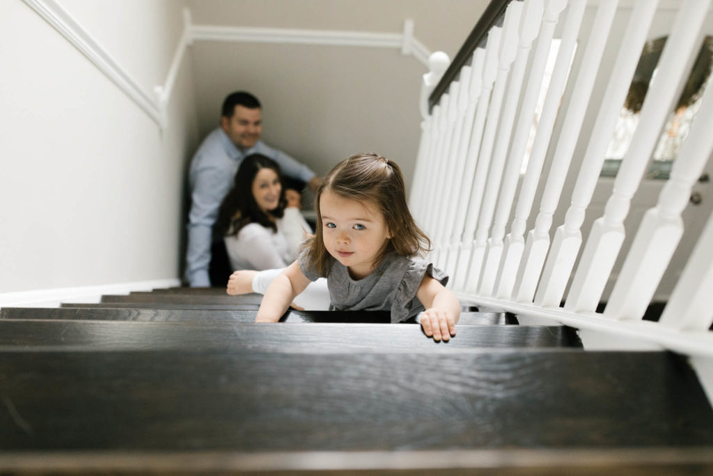 family of four posing in a stair case during lifestyle session 