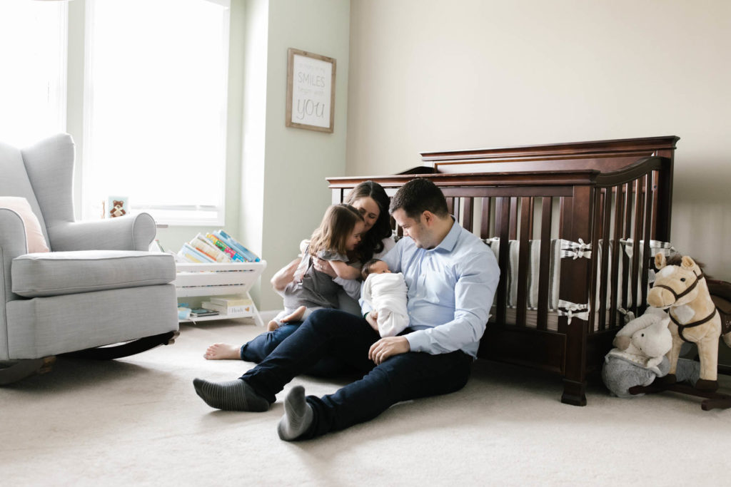 family of four in a nursery during lifestyle family session, photo by Elle Baker Photography 