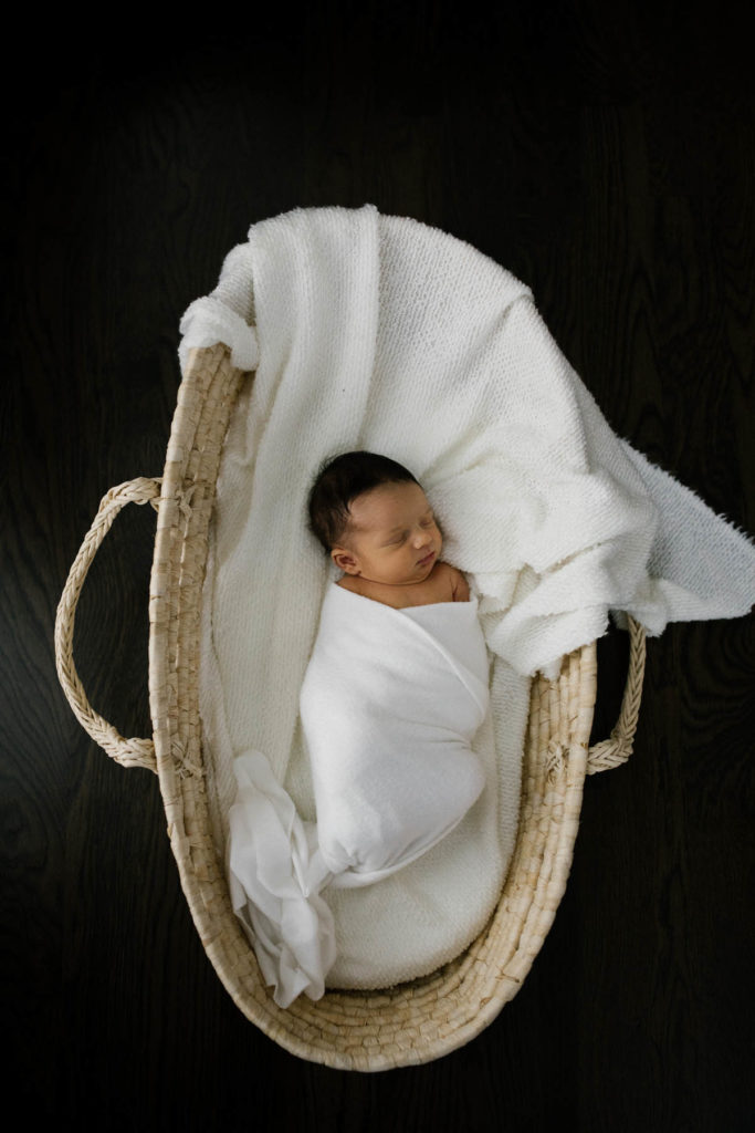Newborn baby photographed in a Moses basket, photography by Elle Baker photography 