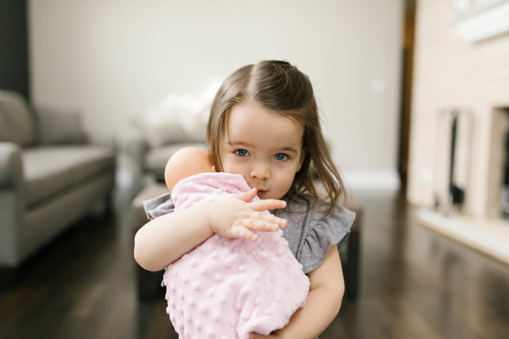 little holds her baby doll 