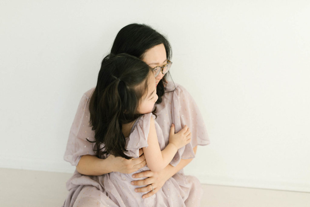 mother and daughter with dark hair embrace during photo session with Elle Baker Photography 