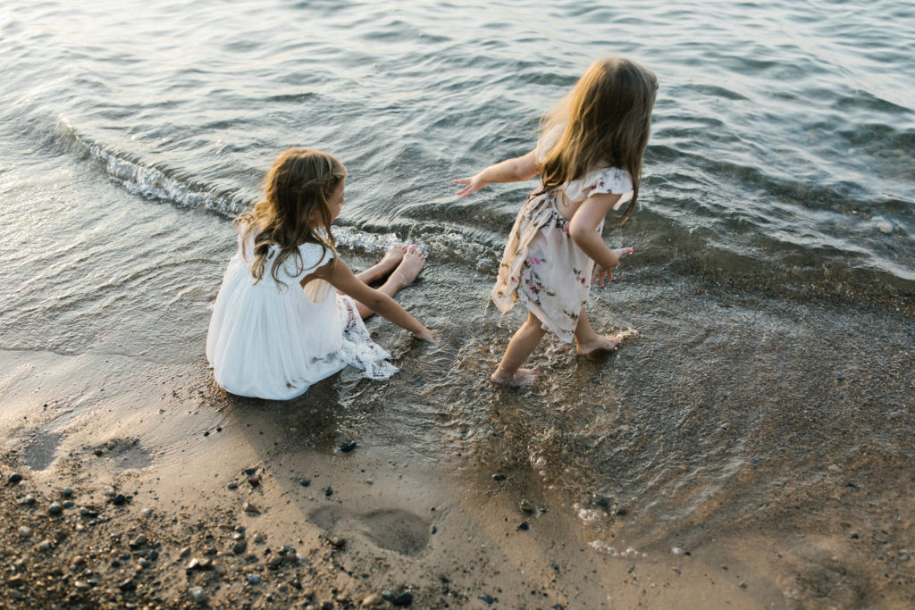 two girls playing in the sand during a beach sunset session with Elle Baker Photography 