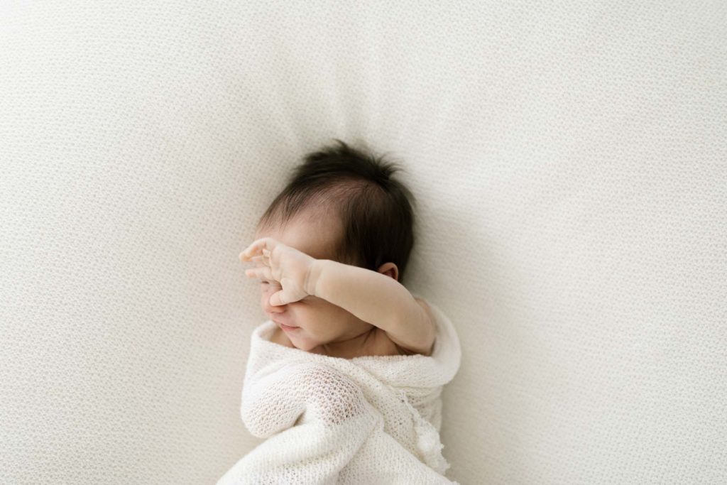 Baby stretches during natural newborn session with Elle Baker Photography 