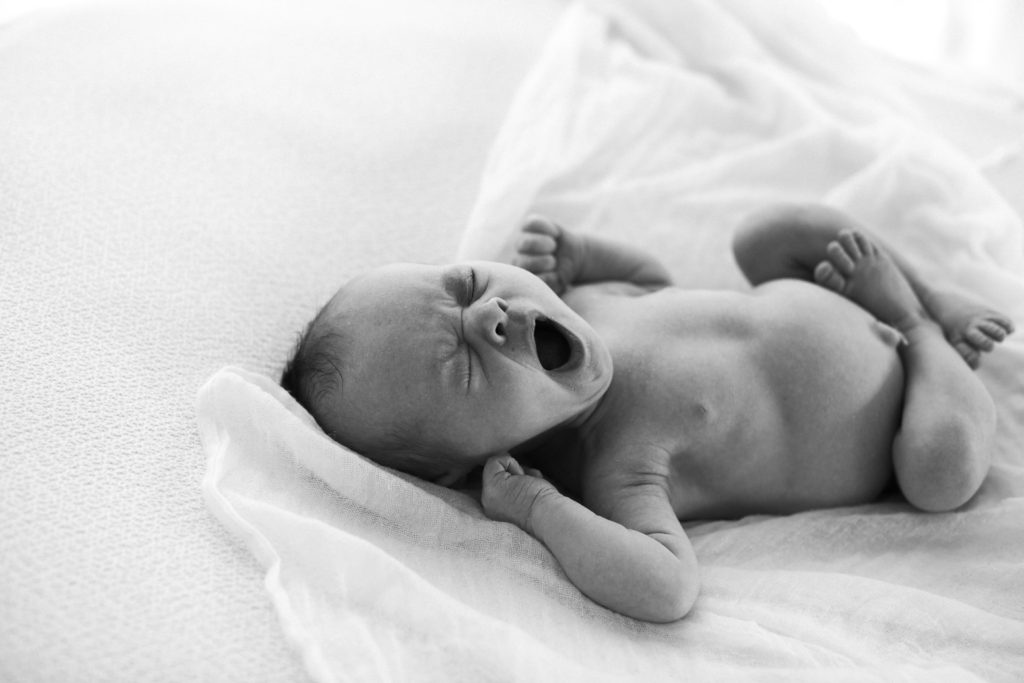 Naperville Newborn Photographer Elle Baker Photography captures yawning newborn photo in black and white