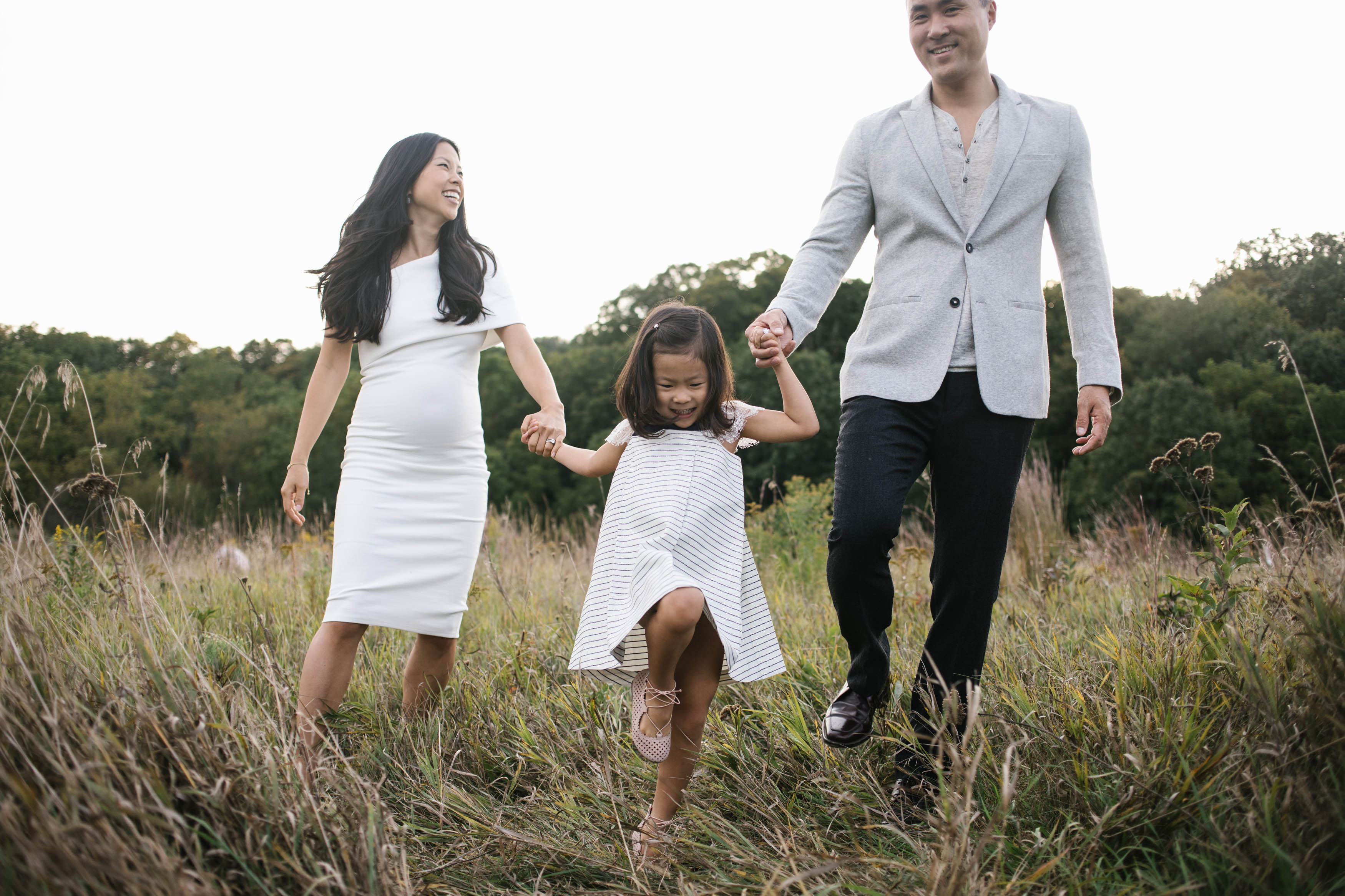 Mokena Illinois Maternity and Family Photographer family of three walking through field laughing