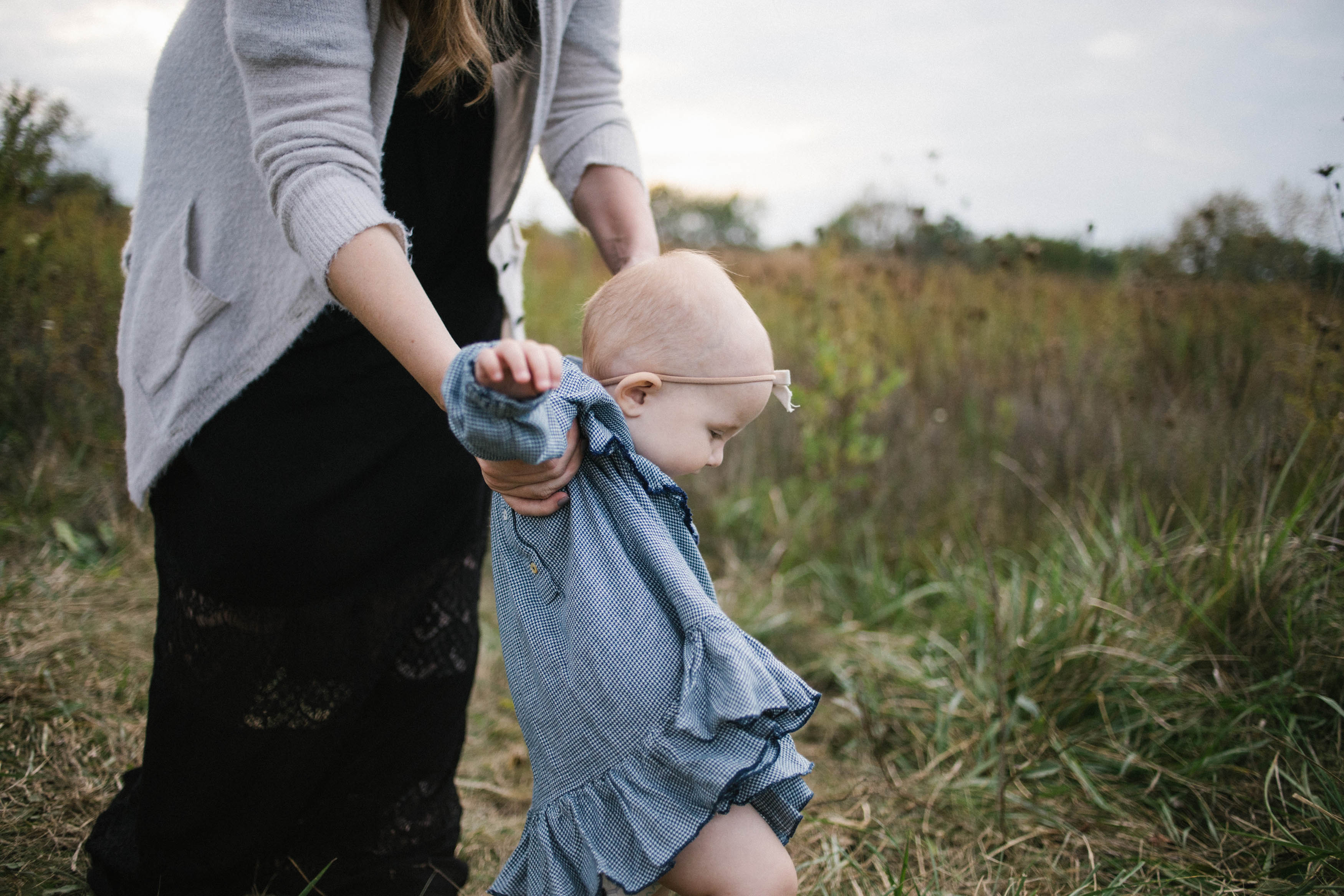 Mom and baby girl walking in a field during sunset session by Elle Baker Photography in Chicago Illinois